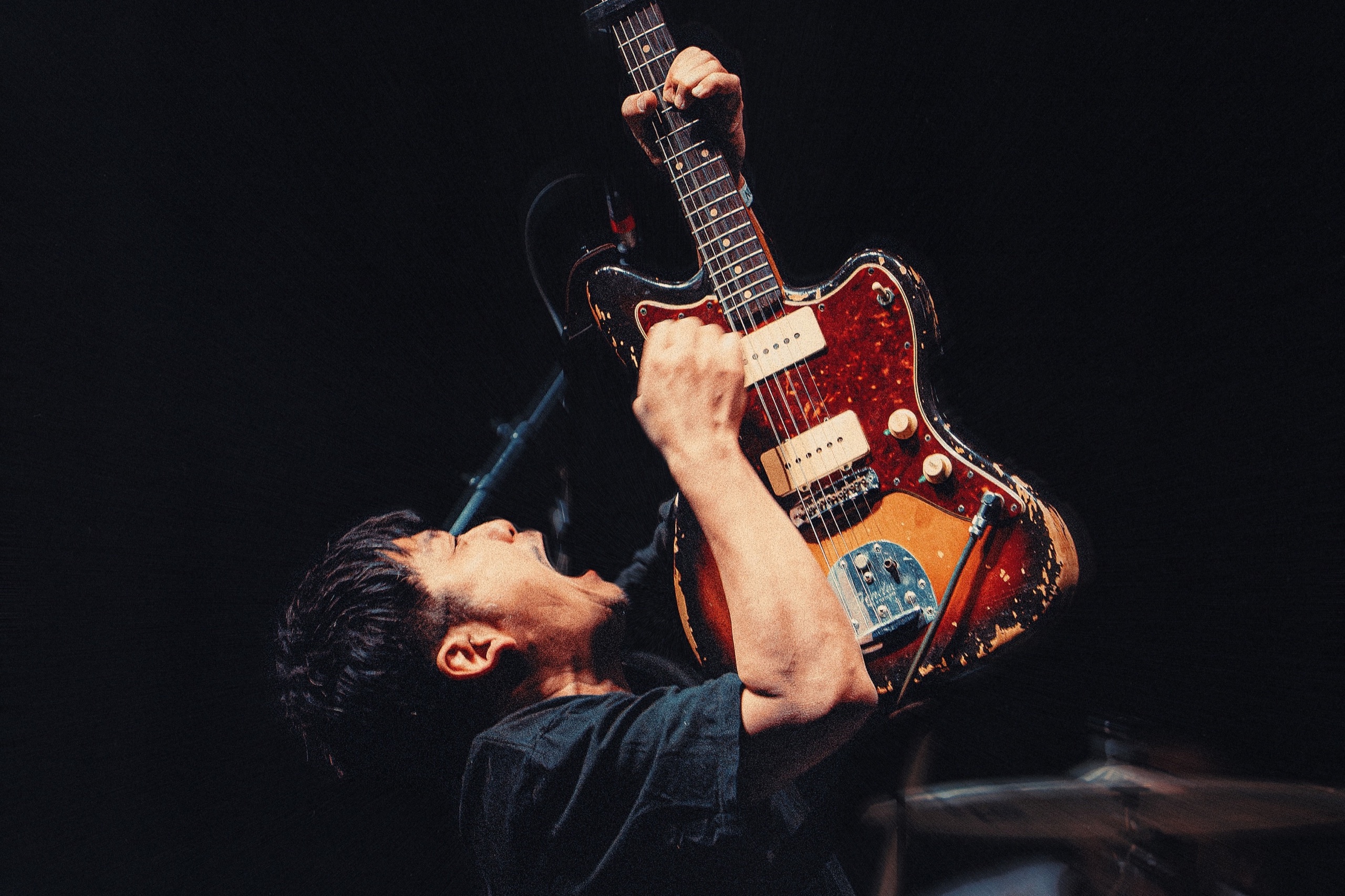 Guitarrista de toe tocando con la guitarra elevada